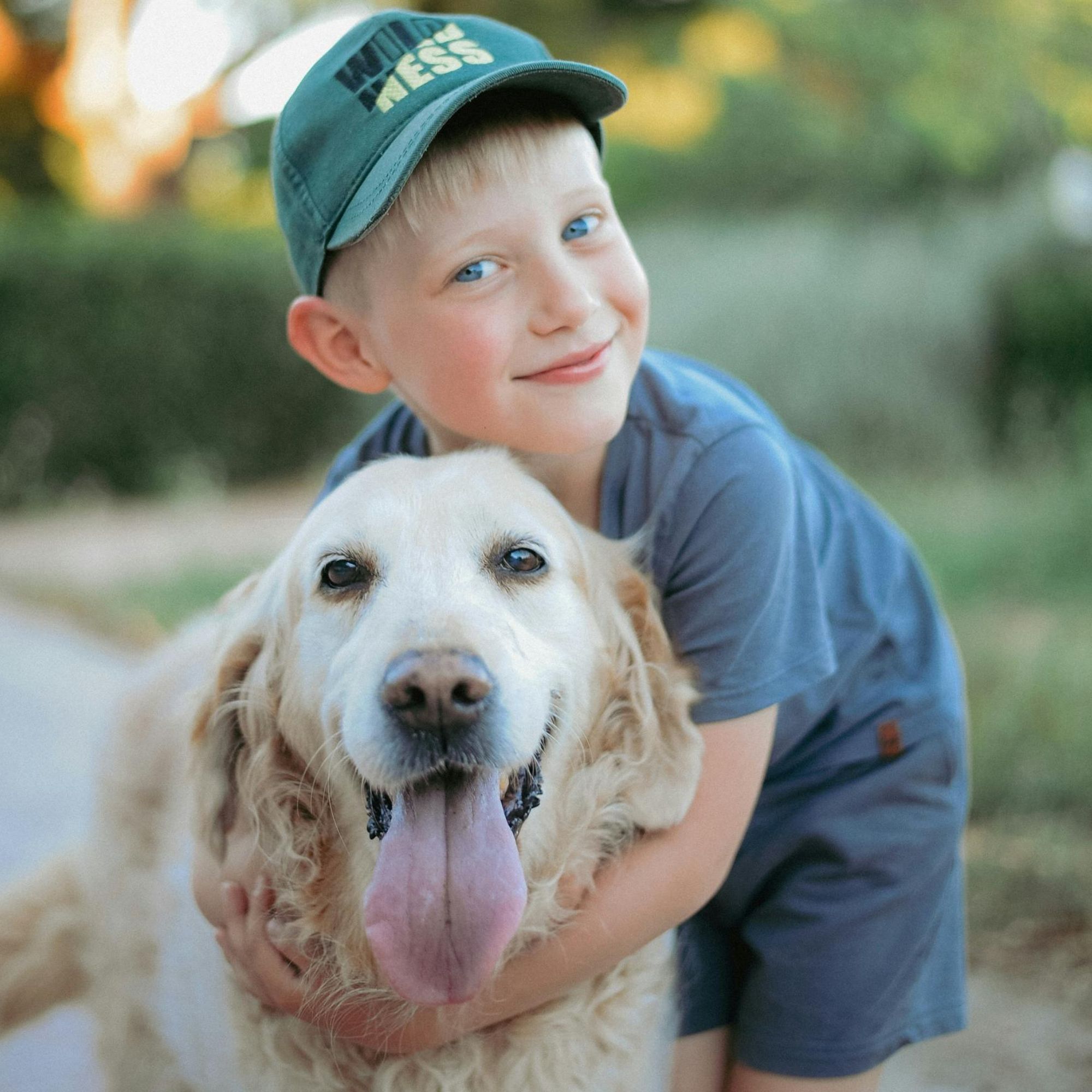 Child hugging a dog outdoors