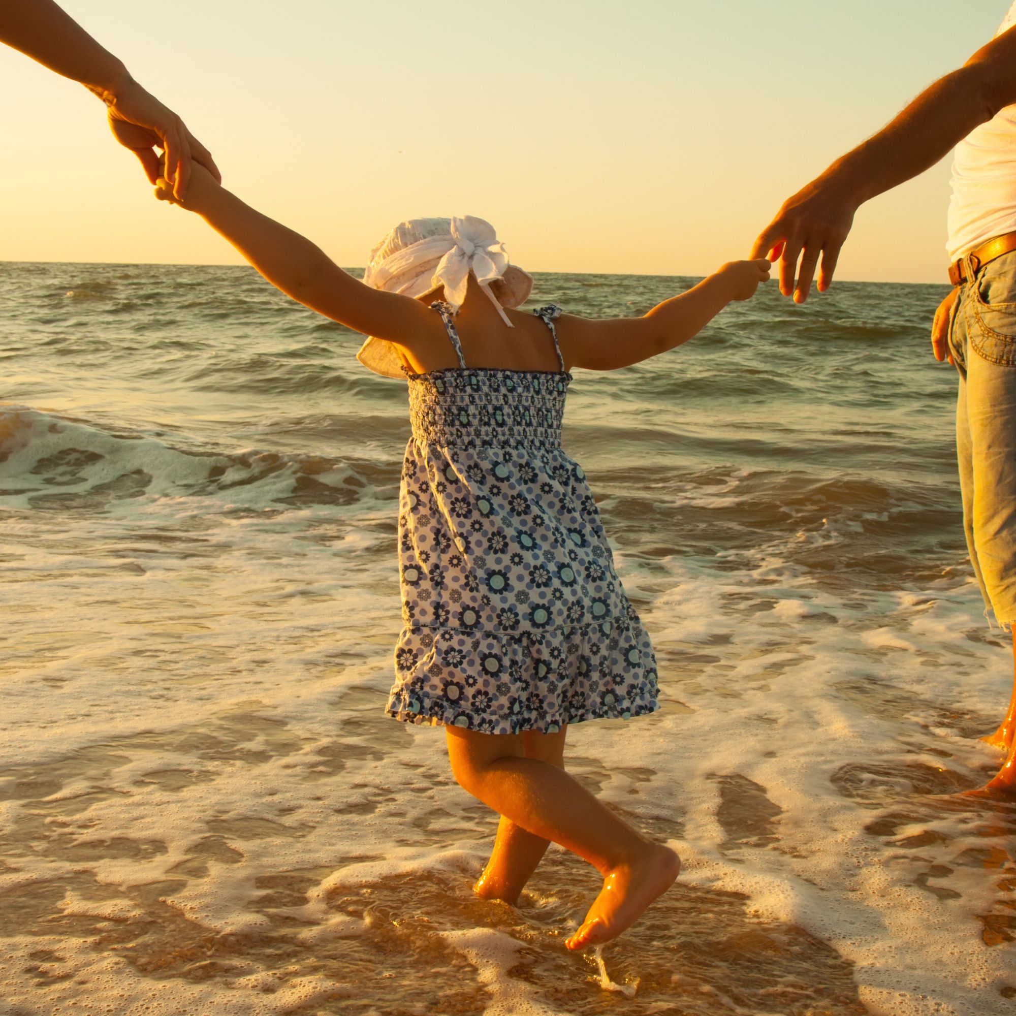 Person relaxing with arms raised on a sunny beach